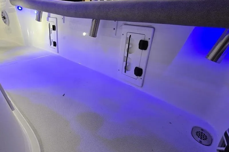 Slide: The Image of 2025 Sea Hunt BX 25 FS boat interior with blue LED lighting and storage compartments. - 14