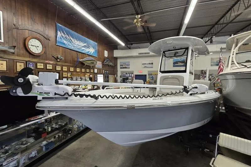 Slide: The Image of 2025 Sea Hunt BX 25 FS boat displayed in a showroom with fishing equipment. - 5