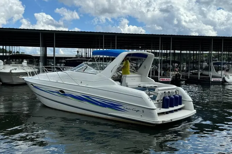 The Image of 1994 Chris-Craft 322 Crowne boat docked at marina under cloudy sky. - 1