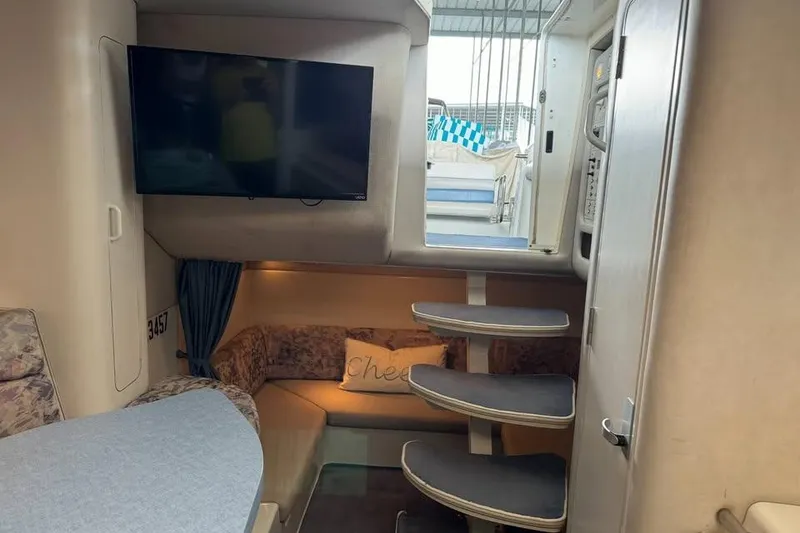 Slide: The Image of Interior of 1994 Chris-Craft 322 Crowne boat with TV and cozy seating area. - 17
