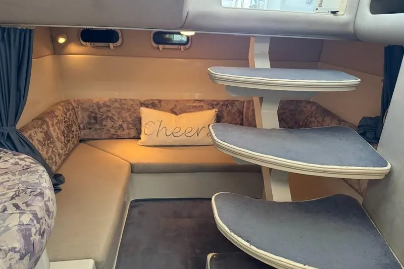 Slide: The Image of 1994 Chris-Craft 322 Crowne cabin interior with curved seating and stairs. - 6