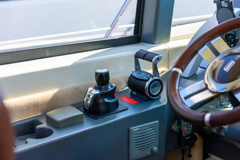 Slide: The Image of Cockpit controls of a 2011 Azimut 68S yacht, featuring steering wheel and throttle levers. - 21