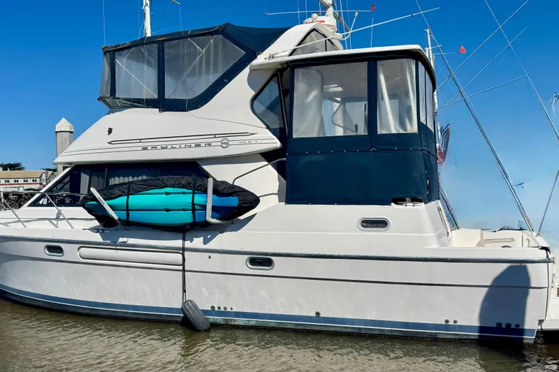 The Image of 1998 Bayliner 4087 Aft Cabin Motoryacht docked with kayak on side. - 0