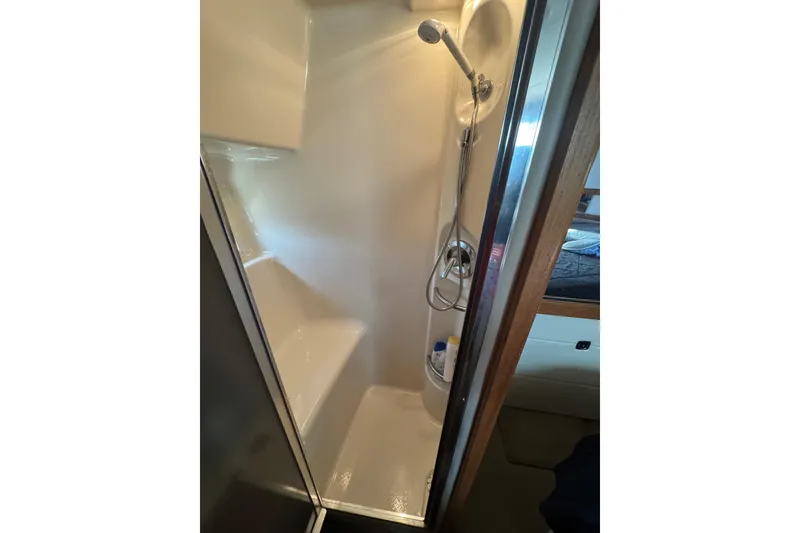 Slide: The Image of Shower area in 1998 Bayliner 4087 Aft Cabin Motoryacht, featuring compact design and handheld showerhead. - 17