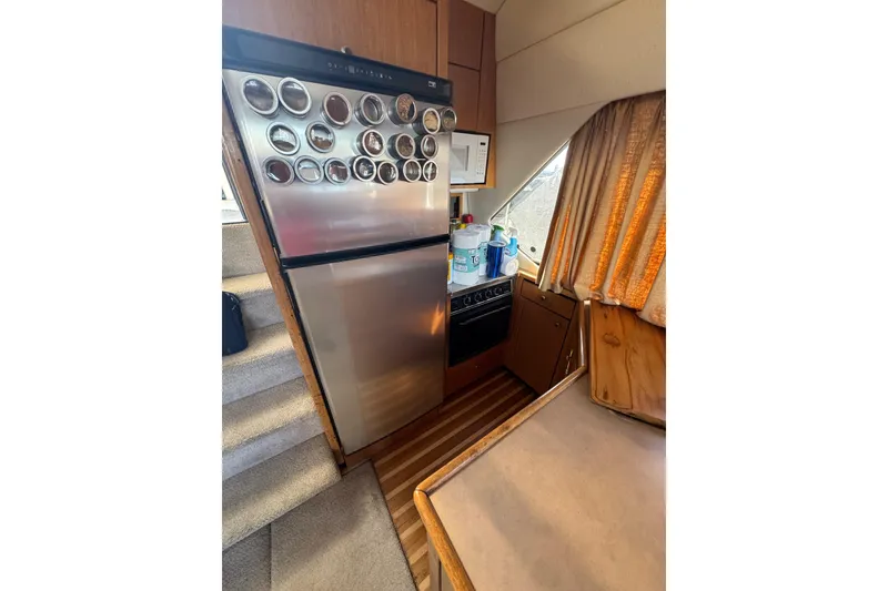 Slide: The Image of 1998 Bayliner 4087 Aft Cabin Motoryacht kitchen with stainless steel fridge and wooden cabinetry. - 20