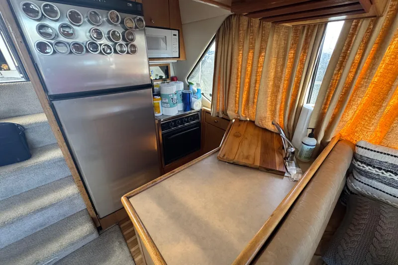 Slide: The Image of 1998 Bayliner 4087 Aft Cabin Motoryacht interior with kitchen and dining area. - 24