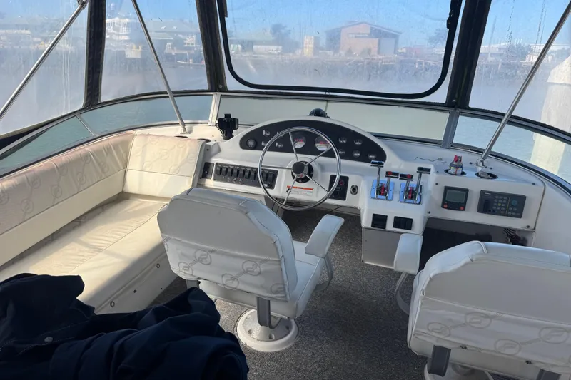 Slide: The Image of 1998 Bayliner 4087 Aft Cabin Motoryacht helm with seating and control panel. - 3