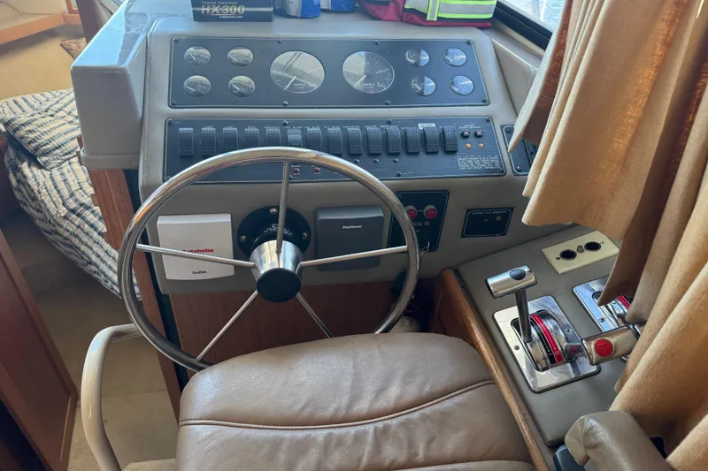 Slide: The Image of 1998 Bayliner 4087 Aft Cabin Motoryacht helm with steering wheel and control panel. - 33