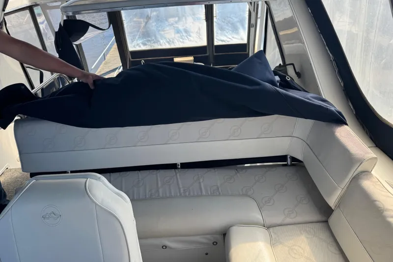 Slide: The Image of 1998 Bayliner 4087 Aft Cabin Motoryacht interior with white seating and dark cover. - 6