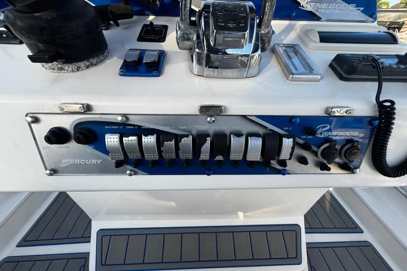 Slide: The Image of Control panel of a 2012 Renegade 32 CC boat with Mercury switches and throttle. - 11