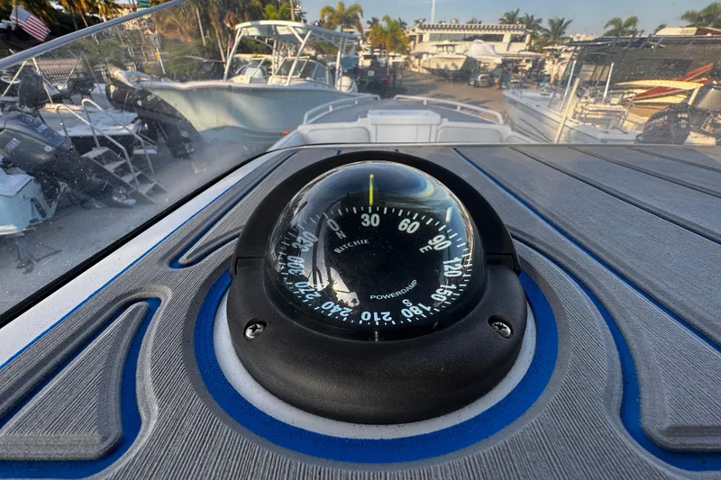 Slide: The Image of Compass on 2012 Renegade 32 CC boat dashboard, marina background. - 19