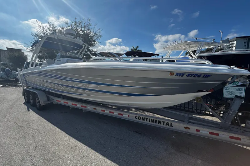 Slide: The Image of 2012 Renegade 32 CC boat on trailer under clear blue sky. - 2