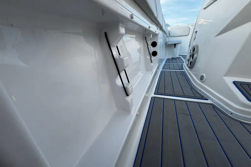 Slide: The Image of Interior view of a 2012 Renegade 32 CC boat, featuring sleek white surfaces and modern flooring. - 21