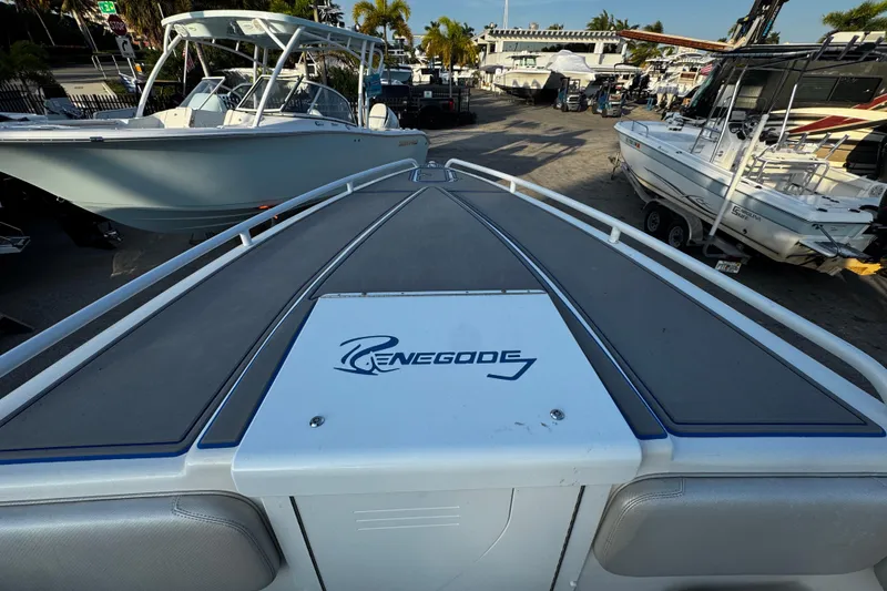 Slide: The Image of 2012 Renegade 32 CC boat deck view at a marina with other boats. - 27