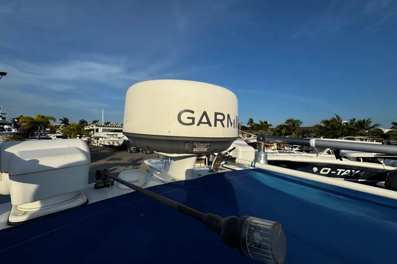 Slide: The Image of 2012 Renegade 32 CC boat with Garmin radar, docked under clear blue sky. - 33