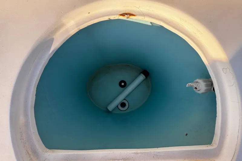 Slide: The Image of 2012 Renegade 32 CC boat livewell interior with blue lining and drain plug. - 38