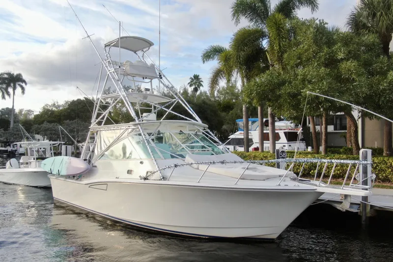 Slide: The Image of 2001 Cabo 35 Express boat docked near palm trees and waterfront homes. - 11