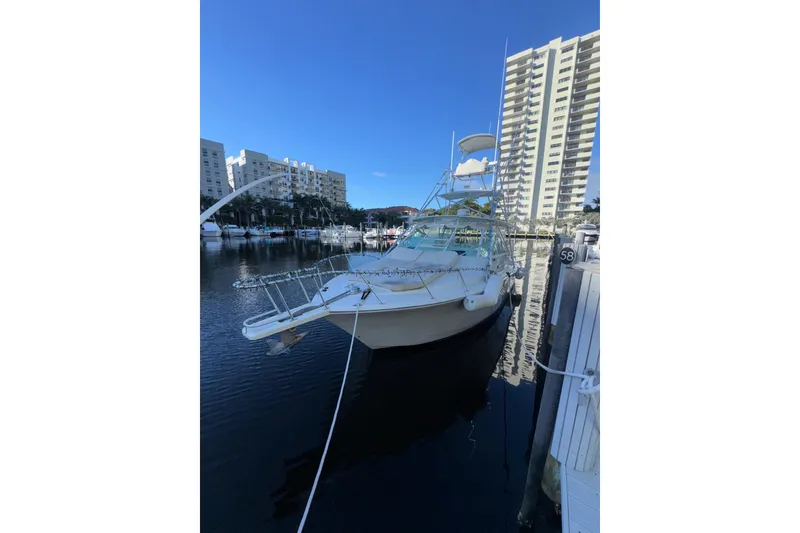 Slide: The Image of 2001 Cabo 35 Express yacht docked in marina with high-rise buildings in background. - 4