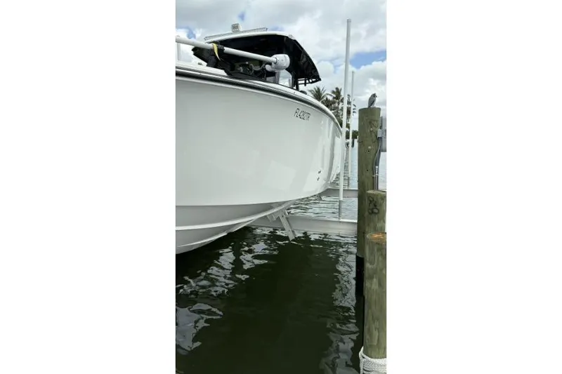 Slide: The Image of 2024 Fountain 32 NX Sportfish boat docked on a lift, side view. - 11