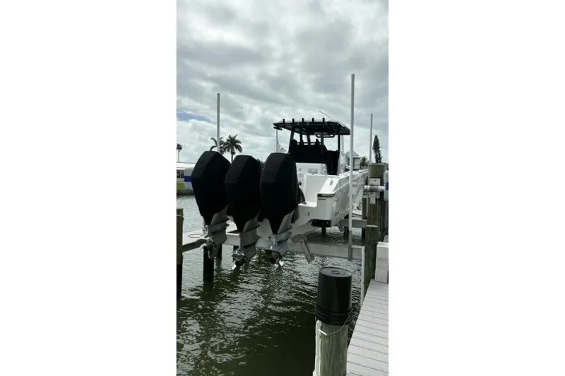 Slide: The Image of 2024 Fountain 32 NX Sportfish boat docked with triple outboard engines. - 14