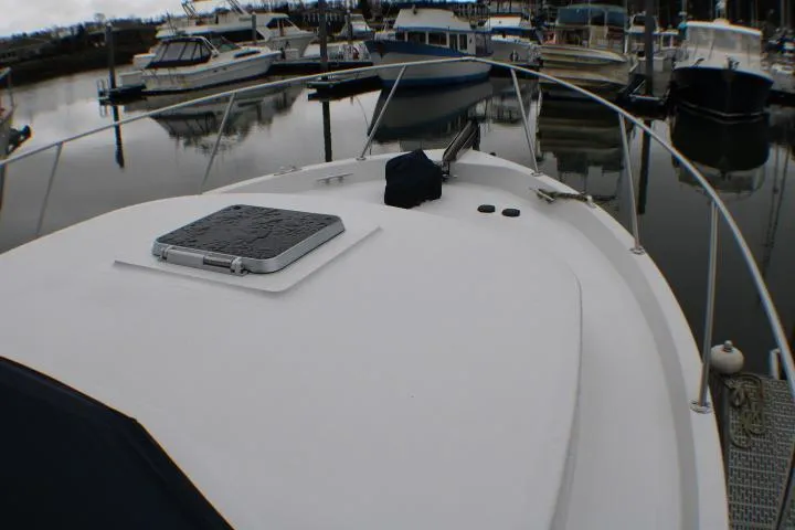 Slide: The Image of 1986 Lynnwood Flybridge Sedan boat docked in a marina with other vessels. - 10