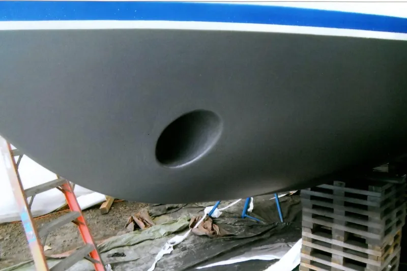 Slide: The Image of 1986 Custom Lynnwood Flybridge Sedan hull with a bow thruster, supported on blocks. - 100
