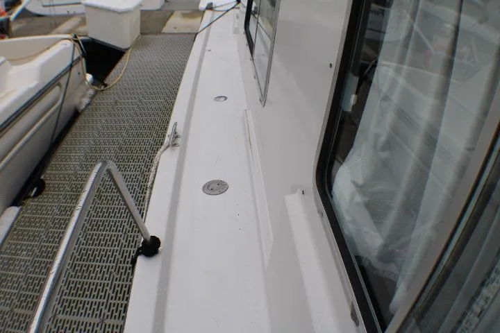 Slide: The Image of 1986 Lynnwood Flybridge Sedan boat deck with railing and window view. - 14