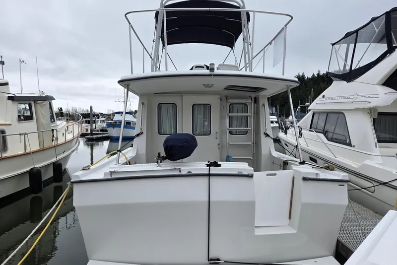 Slide: The Image of 1986 Lynnwood Flybridge Sedan docked at marina, rear view. - 15