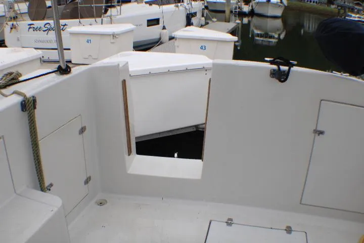 Slide: The Image of 1986 Lynnwood Flybridge Sedan boat deck with open hatch, docked at marina. - 20