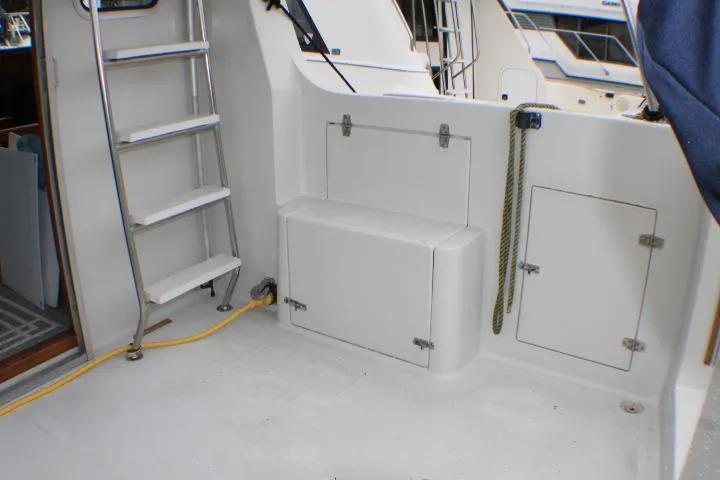 Slide: The Image of 1986 Lynnwood Flybridge Sedan boat deck with ladder, storage compartments, and rope. - 21