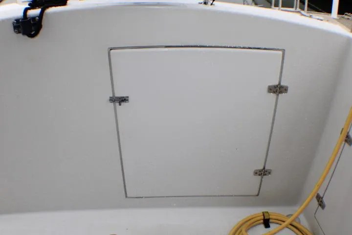 Slide: The Image of 1986 Lynnwood Flybridge Sedan boat hatch with coiled yellow hose on deck. - 26