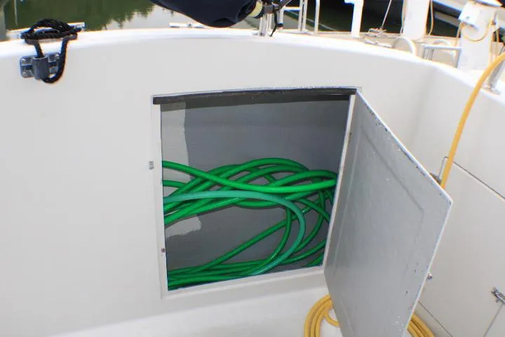 Slide: The Image of Storage compartment on 1986 Lynnwood Flybridge Sedan with green hose inside. - 27