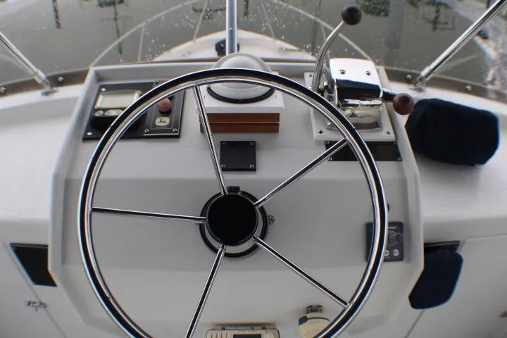 Slide: The Image of Steering wheel and controls of a 1986 Lynnwood Flybridge Sedan boat. - 31