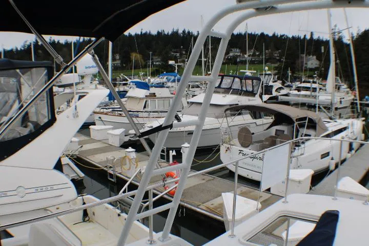 Slide: The Image of Marina with various boats, including a 1986 Lynnwood Flybridge Sedan, docked in a scenic harbor. - 37