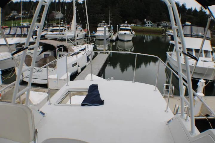 Slide: The Image of 1986 Lynnwood Flybridge Sedan docked at marina with surrounding boats. - 38