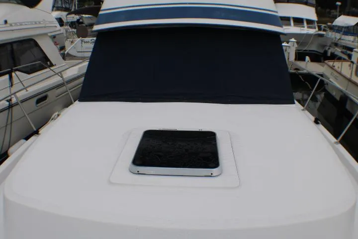 Slide: The Image of 1986 Lynnwood Flybridge Sedan boat deck with hatch, docked among other vessels. - 4