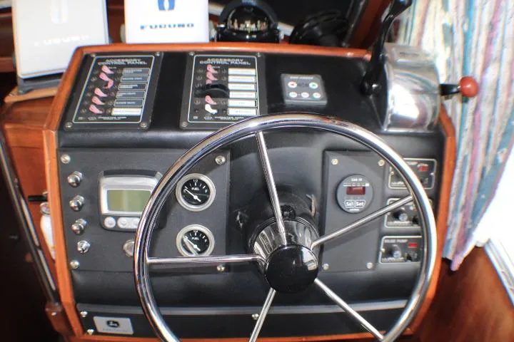Slide: The Image of 1986 Lynnwood Flybridge Sedan helm with steering wheel and control panel. - 43