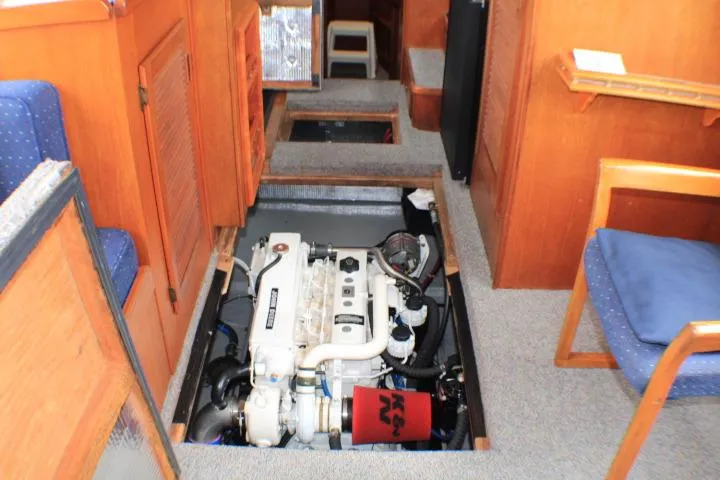 Slide: The Image of 1986 Lynnwood Flybridge Sedan interior with engine compartment exposed, showcasing marine engine details. - 52