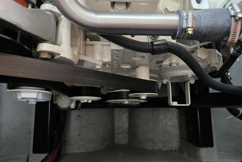 Slide: The Image of Engine components of a 1986 Lynnwood Flybridge Sedan, featuring belts and hoses. - 60