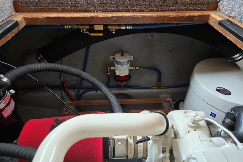 Slide: The Image of Engine compartment of a 1986 Lynnwood Flybridge Sedan boat, showing hoses and components. - 62