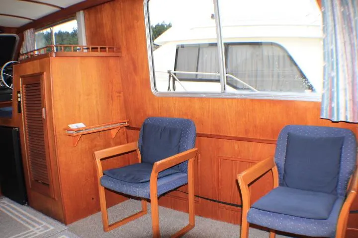 Slide: The Image of Interior of 1986 Lynnwood Flybridge Sedan with wooden paneling and blue cushioned chairs. - 75
