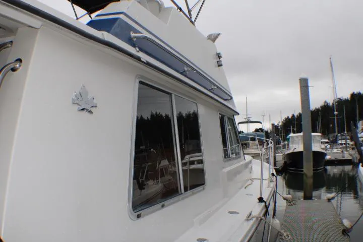 Slide: The Image of 1986 Lynnwood Flybridge Sedan docked at a marina, showcasing sleek design and nautical features. - 8