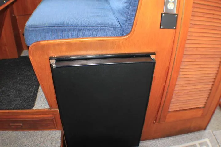 Slide: The Image of 1986 Lynnwood Flybridge Sedan interior with blue seating and wooden cabinetry. - 83