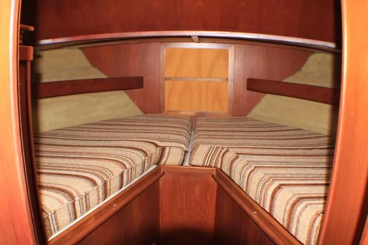 Slide: The Image of Interior cabin of 1986 Lynnwood Flybridge Sedan with striped cushions and wooden finish. - 86