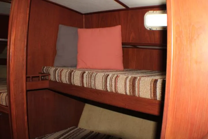 Slide: The Image of Interior of 1986 Lynnwood Flybridge Sedan with wooden bunk beds and cushions. - 91