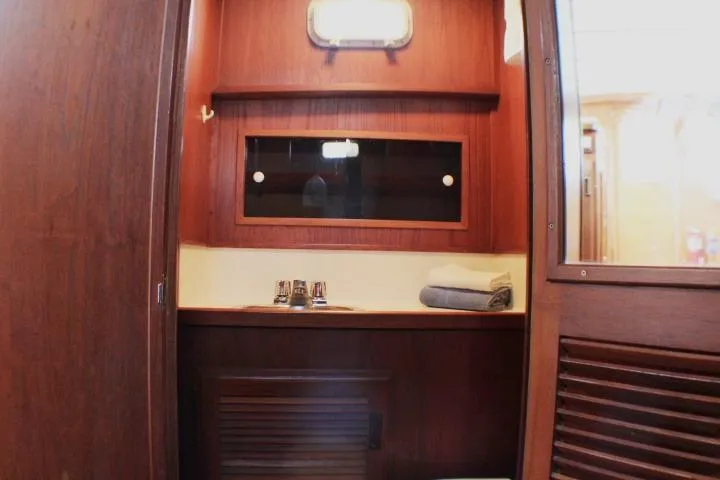 Slide: The Image of 1986 Lynnwood Flybridge Sedan interior with wooden cabinetry and sink area. - 94