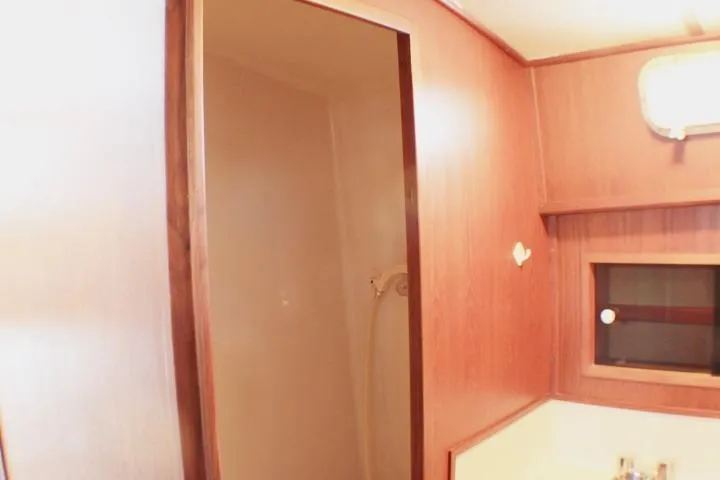 Slide: The Image of 1986 Lynnwood Flybridge Sedan interior with wooden paneling and shower area. - 97