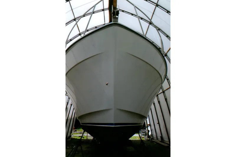 Slide: The Image of 1986 Custom Lynnwood Flybridge Sedan boat under shelter, viewed from the front. - 99