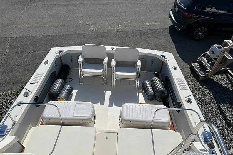 Slide: The Image of 1973 Bertram 28 Flybridge Cruiser deck with chairs and storage, parked on gravel. - 15