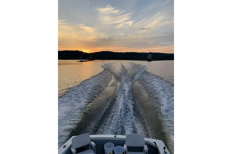 Slide: The Image of Wake behind a 1973 Bertram 28 Flybridge Cruiser at sunset on a calm lake. - 17